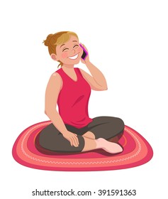 A happy woman in sports clothes sitting on a rug and talking on phone