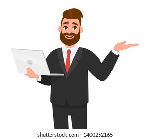 Happy young bearded business man holding/showing a latest new laptop and gesturing, showing, pointing or presenting something to empty copy space side away with hand. Modern technology, digital device