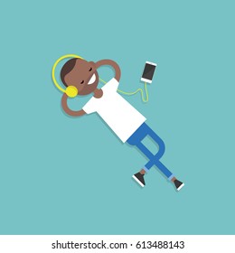 Happy young black man with headphones listening to music on a floor. Top view / flat editable vector illustration