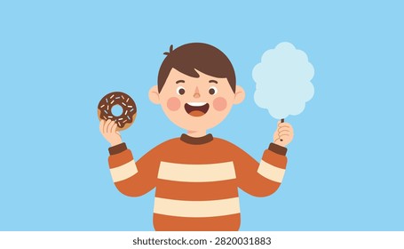 Happy young boy smiling while holding a delicious chocolate donut and fluffy blue cotton candy on a blue background.
