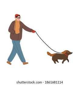 Happy young boy in warm clothing walking his dog in winter park