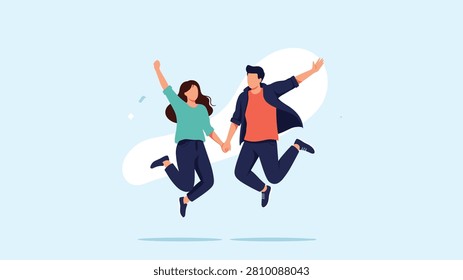 Happy young couple holding hands while jumping together in the air against a light blue background, expressing pure happiness.