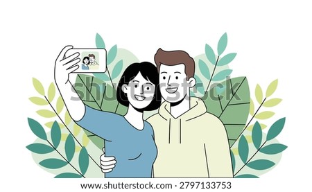 Happy young couple smiling while taking a selfie together with a smartphone against a background of green leaves.