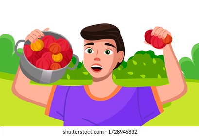 Happy young farmer holding a pan with bright fresh vegetables. Gardener is proud of his harvest. Farm worker on the summer country landscape is telling about plant, green growing, useful agriculture