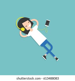Happy young girl with headphones listening to music on a floor. Top view / flat editable vector illustration