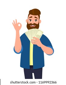 Happy young man holding cash/money/banknotes and gesture okay sign. Financial 
money concept. Vector illustration in cartoon style.