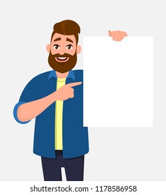 Happy young man holding/showing/displaying white blank board/banner/poster and pointing index finger towards that. Concept illustration in vector cartoon style.