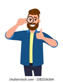 Happy young man looking through magnifier and showing thumbs up gesture sign. Trendy person holding magnifying glass or lens. Positive male character with loupe. Modern lifestyle in vector cartoon.