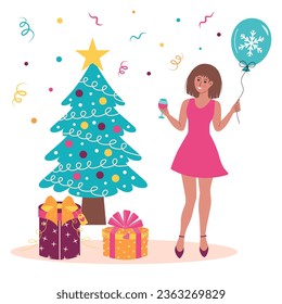 Happy young woman with glass of wine and balloon standing near the Christmas tree and present boxes.  Christmas, New year, party mood.  Winter holidays.