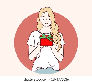 Happy young woman holding a gift box, Christmas celebration. Hand drawn in thin line style, vector illustration.
