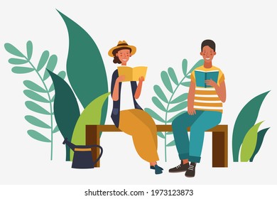 Happy young woman and man reading book in the garden.  Agriculture gardener hobby