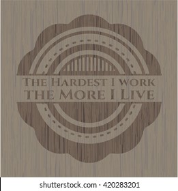 The Hardest I work the More I Live badge with wooden background