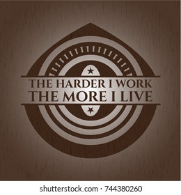 The Hardest I work the More I Live badge with wood background