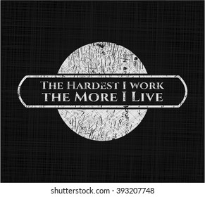 The Hardest I work the More I Live chalkboard emblem written on a blackboard