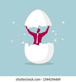 Hatching concept, a businessman opens the egg, isolated on blue background.