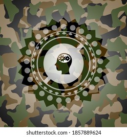 head with gears inside icon inside camouflaged emblem. 