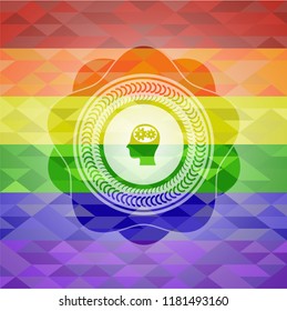 head with gears inside icon inside emblem on mosaic background with the colors of the LGBT flag