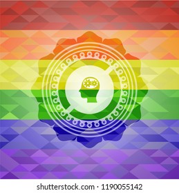 head with gears inside icon inside emblem on mosaic background with the colors of the LGBT flag