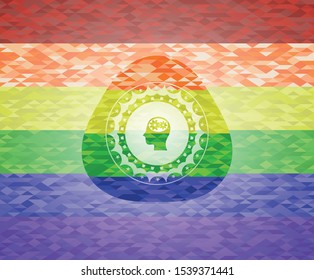 head with gears inside icon inside emblem on mosaic background with the colors of the LGBT flag