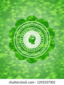 head with gears inside icon inside green emblem with triangle mosaic background