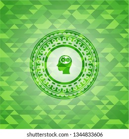 head with gears inside icon inside green emblem with triangle mosaic background