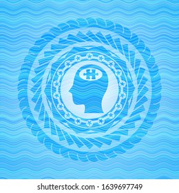 head with jigsaw puzzle piece icon inside light blue water wave style emblem.