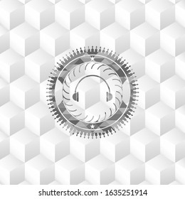 headphones icon inside grey emblem with geometric cube white background