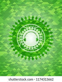 headphones icon inside realistic green mosaic emblem