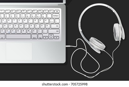 The headphones and the laptop are on the table, connected to each other. Listening to music from the laptop. A white laptop on a black table. EPS 10 vector illustration