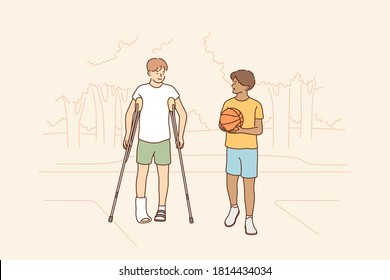 Health, care, sport, basketball, friendship concept. Young boys children african american guy holding ball and disabled friend with crutches walking together. Friendly support and rehabilitation.