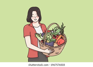 Healthy food and vegetarian diet concept. Young happy positive woman cartoon character standing and holding basket with fresh raw organic vegetables and fruits in hands vector illustration 