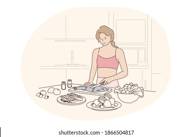 Healthy homemade food, clean eating, diet concept. Young positive woman standing in kitchen and cooking fish with fresh vegetables for dinner at home alone. Wellness, bodycare, healthy lifestyle
