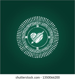 heart with arrow icon inside chalkboard emblem written on a blackboard