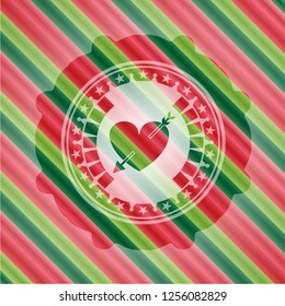 heart with arrow icon inside christmas emblem.