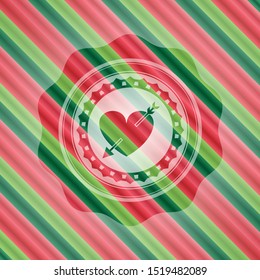 heart with arrow icon inside christmas colors style badge.