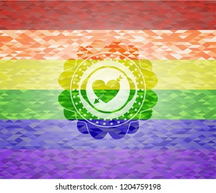 heart with arrow icon inside emblem on mosaic background with the colors of the LGBT flag