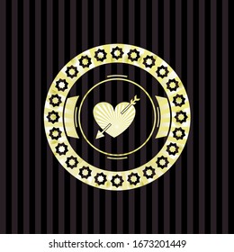 corazón con icono de flecha dentro del emblema dorado