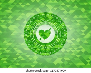 heart with arrow icon inside green emblem with mosaic background