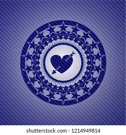 heart with arrow icon inside jean or denim emblem or badge background