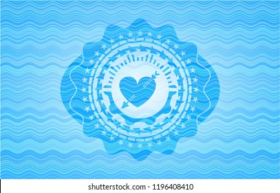 heart with arrow icon inside light blue water wave emblem background.