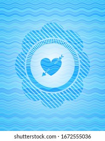 heart with arrow icon inside light blue water style emblem.