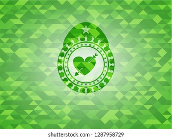 heart with arrow icon inside realistic green mosaic emblem