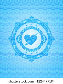 heart with arrow icon inside water wave style emblem.