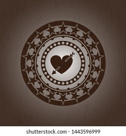 heart with arrow icon inside wooden emblem