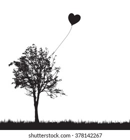 A heart balloon stuck in a tree.