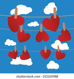 Heart clipped on rope on blue sky with clouds