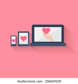 Heart displayed on three different portable electronics, mobile phone, tablet PC and laptop, symbol of social networking, preferences, relationship status or online dating and flirting, on pink