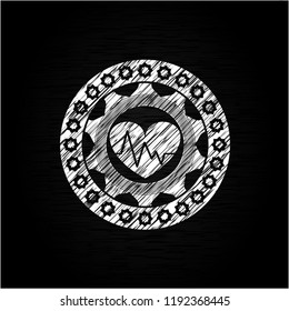 heart with electrocardiogram icon drawn on blackboard
