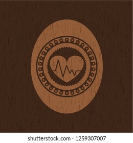 heart with electrocardiogram icon inside badge with wood background