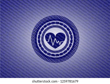 heart with electrocardiogram icon inside badge with denim texture